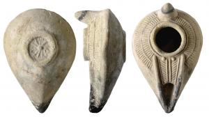 LMP-6093 - Lampe moulée bec en Vterre cuiteTPQ : 700 - TAQ : 900Moulée. Anse en tenon conique. Réservoir en forme d'amande au profil biconique. Bandeau décoré de palmes stylisées autour d'un grand trou de mèche bordé d'un bourrelet. Bec pointu à canal en V  limité par un bourrelet. Il porte une palme et deux globules au départ.  Petite base circulaire en creux, porte un décor de traits rayonnants en relief.