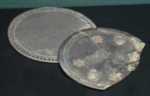 MRR-4004 - Miroir Lloyd-Morgan Group K : à bordure trouée
bronze
Miroir circulaire, dont la bordure est percée d'une succession de trous rapprochés, plus ou moins régulièrement disposés selon les cas ; la face externe est ornée de cercles concentriques disposés en groupes. Manche de forme variable, souvent en boucle ou en balustre, fixé par brasure sur un côté du disque, à l'emplacement où la bordure trouée s'interrompt.