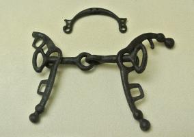 MRS-2017 - Mors de type Rimini
bronze
Morsa à canon articulé, deux longues appliques en arc de cercle, extrémités bouletées, pourvues de bélières pour des sangles permettant la conduite précise du cheval.