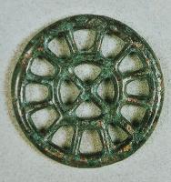 PDQ-2034 - Pendeloque en forme de rouelle
bronze
Rouelle coulée, à décor ajouré, sans anneau de suspension sommital ; variante à 12 rayons et croisillon central.