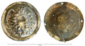 PHA-4014 - Phalère : gorgoneion
argent
Phalère circulaire en tôle, ornée au repoussé d'une tête de Méduse, ailée, le visage aux traits tourmentés encadré de mèches désordonnées et  de serpents; bordure lisse, au revers de laquelle on observe 4 rivets pour la fixation sur le harnais de dona militaria.