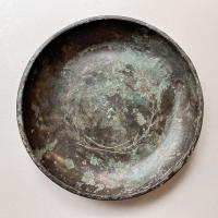 PHI-4005 - Phiale à décor incrusté
bronze, argent
Phiale à fond plat, bord arrondi et lèvre épaissie en triangle ; décor gravé et incrusté d'argent (couronne, guirlande) et de cuivre rouge.