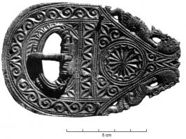 PLB-4020 - Plaque-boucle à décor excisé
bronze
Plaque-boucle à décor excisé de forme allongée, arrondie vers l'avant et triangulaire (ces côtés ornés d'une frise d'animaux) à l'arrière : la boucle, à extrémités zoomorphes affrontées, est inscrite dans un ajour. Décor excisé couvrant, de type géométrique, organisé autour d'un motif circulaire dans la partie triangulaire. La contre-plaque prend la forme d'un ovale formé de deux demi-cercles adossés, décor assorti à la plaque-boucle.