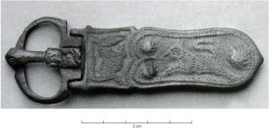 PLB-5578 - Plaque-boucle lyriforme wisigothiquebronzeTPQ : 600 - TAQ : 700Plaque-boucle lyriforme (bords concaves, extrémité arrondie), à décor animalier : à l'extrémité distale, trois motifs circulaires spiralés encadrent une figure d'animal en course, peut-être un lion; au contact de la charnière, un caisson transversal est également orné d'une figure animale (cheval ?); trois bélières de fixation au revers.