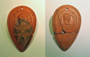 PLV-4008 - Plaquette votive : Antinoüs divinisé
terre cuite
Plaquette moulée, en forme de pétale, avec un médaillon figurant le buste d’Antinoüs, encadré de guirlandes. Autour, inscription en caractères grecs ANTINOON ΘΕON N ΠΑTPΙC.