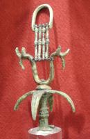 PYX-2001 - Pyxide étrusque
bronze
Objet composite : corps concave en deux parties de bronze non jointives, de profil concave;  sommet avec tige centrée verticale, suivie de pétales retombant, puis d'un aceau à extrémités zoomorphes et enfin d'une suspension sommitale pouvant être constituée de barrettes accolées sous un arceau.