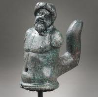 SCH-4004 - Suspension de caisse de char : barbare
bronze
Suspension de caisse de char constituée d'une robuste douille en forme de buste humain, posé sur une moulure; le corps musculeux est surmonté d'une tête d'homme barbu, coiffé au bol (prisonnier barbare ? Germain ?); sur la face arrière, robuste crochet anguleux en forme de doigt.