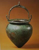 SIT-3022 - Kados
bronze
Situle à corps ovoïde, fond en obus et col étranglé, bord déversé; anse mobile articulée sur deux attaches fixées par brasure sur le bord, et surmontées d'un anneau.