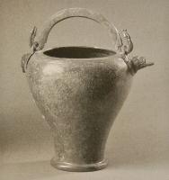 SIT-3026 - Situle stamnoïde à déversoir
bronze
Situle à panse tronconique légèrement renflée : pied étroit, bord à peine rentrant; équipée de deux anses mobiles sur des attaches figurées à double œillet, dont l'une forme aussi un verseur à tête de chien ou de loup.