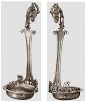 SPL-4014 - Simpulum
argent
Simpulum à vasque rapportée (profil écrasé à fond plat, bord horizontal) ; le manche très orné comporte une base ajourée encadrée de volutes, une tige plate à bords concaves, cannelée sur les bords, et un sommet en crosse surmonté d'un crochet zoomorphe (tête de cerf).