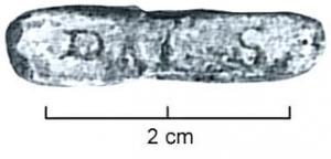 TES-4042 - Tessère rectangulaire : DAL S
plomb
Fragment de plomb de forme rectangulaire, écrasé par l'apposition d'une marque estampée sur une face, sans cartouche : DAL  S (D incertain);  perforation transversale. Revers lisse.
