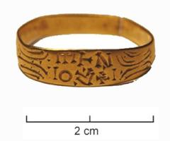 BAG-5091 - Bague rubannéeorTPQ : 500 - TAQ : 700Simple ruban, ouvert, orné de motifs géométrique autour d'un chaton à peine individualisé par un aplatissement ; inscription gravée non rétrograde.