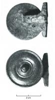 BTA-4002 - Bouton à anneaubronzeBouton constitué d'un large disque mouluré sur la face supérieure, dont part au revers une tige immédiatement coudée latéralement, et terminée par une barre transversale.