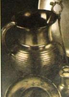 CRU-2002 - CrucheargentCruche à corps renflé et couvert de cannelures horizontales; col cylindrique légèrement évasé; anse massive en arc de cercle posée sur la lèvre et l'épaule.