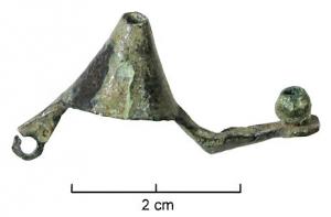 FIB-3531 - Fibule à timbale coniquebronzeFibule dont l'arc est occupé par une timbale conique, généralement surmontée d'un cabochon de corail ; timbale lisse ou cannelée de cercles concentriques. La tête de l'arc peut se prolonger directement par le ressort, ou être percée pour le passage d'un axe pour ressort rapporté.