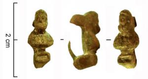 FIB-4393 - Fibule skeuomorphe : bustebronzeFibule en forme de minuscule buste d'homme barbu, la tête légèrement tournée à gauche; le socle du buste présente sur la face antérieure un cartouche rectangulaire en retrait.