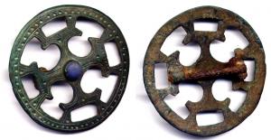 FIB-5022 - Fibule discoïdalebronzeFibule circulaire ajourée, comportant une croix pattée, isncrite dans un cercle; décor de ponctuations et gravures; cabochon central de verre bleu.