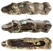 FIB-6096 - Fibule zoomorphe : ?bronzeFibule en forme d'animal tapi (crocodile ? grenouille...); le revers creux masque un anneau pour l'articulation d'une aiguille et une barrette en guise de porte-ardillon.