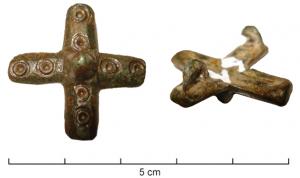 FIB-6112 - Fibule cruciformebronzeFibule en forme de croix latine, à quatre branches égales et épaisses, marquées de cercles oculés, autour d'un umbo lisse, en fort relief.