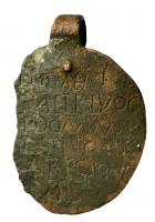 IND-4176 - Etiquette d'esclave ?bronzePlaque de tôle, ovale, avec une boucle de suspension rivetée ; sur une face, texte incisé mentionnant l'esclave et son propriétaire.