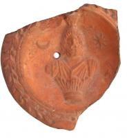 LMP-4379 - Lampe Loeschcke VIII : Sarapisterre cuiteLampe à bec rond (fragment); disque orné du buste de Sarapis entre le soleil et le croissant de lune. Argile orange engobe orange; base plate.