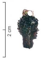 PDT-4023 - Pendant : tête négroïdeverrePendant moulé en forme de tête humaine aux cheveux crépus, en verre teinte (couleur miel à brune), avec au sommet du crâne une bélière de suspension dégagée dans la masse.