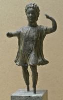 STE-4320 - Statuette : Lare ?bronzeFigurine masuline,  vêtue d'une tunique dont le bord forme des plis indiquant un mouvement vif; les deux bras sont écartés et la main gauche relevait tenait un objet disparu (rhyton ?). Incrustations d'argent.