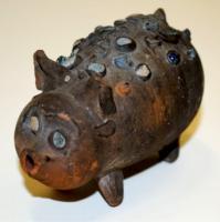 STE-4506 - Statuette zomorphe : porc ou porceletterre cuiteTPQ : 1 - TAQ : 300Figurine au corps tubulaire, tourné, avec pattes, oreilles et queue rapportées ; le corps est parsemé de fragments de verre incrustés dans la pâte, deux d'entre eux figurant les yeux.