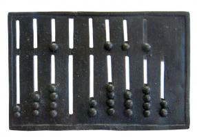 ABA-4001 - AbaquebronzeTable à compter, ou boulier, constituée d'une plaque en bronze, percée de fentes parallèles numérotées, dans lesquelles coulissent des boutons mobiles ; un registre correspond aux unités, l'autre à des blocs de 5 en 5 unités.