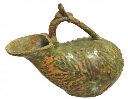 ASK-4004 - Askosterre cuiteVase en forme d'outre, à panse déformée latéralement; l'ouverture est déportée vers l'avant et l'anse surélevée, prenant appui sur la lèvre et sur le bas de la panse ; corps orné de feuilles moulées.