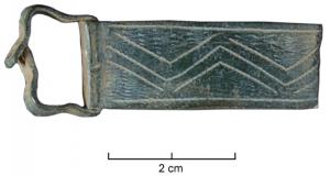 BAC-9001 - Boucle à chape gravéebronzeBoucle à chape rectangulaire, ornée d'un motif incisé continu (frise), généralement de type géométrique.