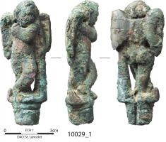 CNF-4101 - Canif : Eros / AmourbronzeManche de canif (fente au revers pour le repli de la lame) figurant un Eros / Amour debout, chevilles croisées, s'appuyant à gauche sur une massue d'Hercule.