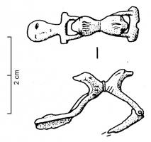 FIB-4072 - Fibule léontomorphebronzeFibule à charnière, arc remplacé par deux protomés de lions adossés, plus ou moins stylisés et posant les pattes antérieures, l'un sur la charnière, l'autre sur une barre transversale ; le pied est ici prolongé par une tête humaine très stylisée.