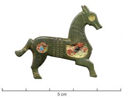 FIB-41743 - Fibule zoomorphe : chevalbronzeTPQ : 120 - TAQ : 260Fibule représentant un cheval à droite, le corps plat creusé de trois loges d'émail, une pastille sur l'arrière-train, une loge plus étendue sur l'épaule et l'œil ; entre elles, des lignes de pointillés et guillochis ; une seule patte est figurée.