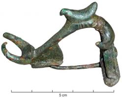 FIB-4660 - Fibule à décor zoomorphe plastiquebronzeFibule à décor plastique, en haut relief : aux deux extrémités de l'arc qui est fortement coudé à la tête, deux paires de cornes de bovidés; au sommet de l'arc, une figurine d'oiseau; long ressort en arbalète, corde externe et griffe.