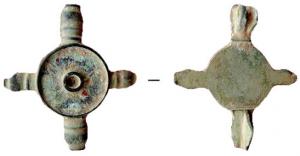 FIB-4912 - Fibule symétrique émailléebronzeFibule symétrique à corps circulaire entre quatre boutons moulurés (ceux de l'axe principal parfois plus développés) ; le motif central comprend un disque central émaillé, entouré d'une ou deux larges couronnes, également émaillées.