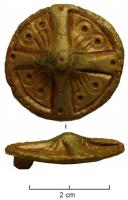 FIB-5118 - Fibule discoïdalebronzeFibule circuliare, avec umbo central moulé en relief, motif cruciforme et décor de cercles oculés dans les écoinçons.