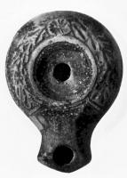 LMP-4093 - Lampe syro-palestinienneterre cuiteLampe à bec en enclume défini par deux traits obliques. Disque nu; épaule ornée d'une couronne de laurier avec en son centre une fleur.