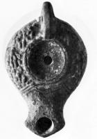 LMP-4095 - Lampe syro-palestinienneterre cuiteLampe à bec en enclume défini par deux traits obliques. Disque nu; épaule ornée d'une couronne de laurier avec baies. Anse percée.