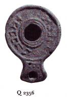 LMP-41048 - Lampe ronde à bec allongé : Texte Palmyrénienterre cuiteLampe ronde à bec allongé. Epaule décorée d'une inscription en palmyrénien dédiée à Abigbol et Malakbêl.