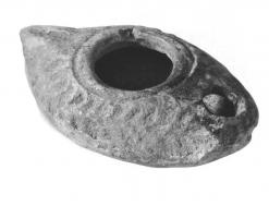 LMP-41508 - Lampe pantoufle byzantine terre cuiteLampe allongée à bec incorporé à canal; épaule décorée de traits formant une couronne de palme en relief. Petite anse conique horizontale.