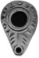 LMP-4177 - Lampe syro-palestinienne tardive (type pantoufle)terre cuiteLampe pantoufle avec inscription grecque sur l'épaule ([[T]]HC [[QEWTOKO]]Y). Au-dessus du bec, un motif en forme de menorah. Bec entouré d'un cercle en relief.