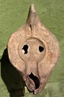 LMP-42052 - Lampe Hayes II : Croixterre cuiteLampe africaine tardive classique. Médaillon orné d'une croix Epaule ornée d'une succession de canthares (ou chandeliers) à pied étranglé. Argile brun-ocre rose, non engobée. Anse à l'arrière