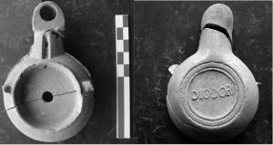 LMP-42488 - Lampe de firme : DIODORIterre cuiteLampe à bec en ogive et canal de bec; disque lisse, trois ergots en relief sur l'épaule. Argile rouge, sans engobe ; sous la base, marque moulée DIODORI