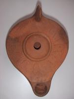 LMP-4580 - Lampe égyptienne tardiveterre cuiteLampe égyptienne tardive. Epaule ornée de motifs géométriques constitués de points en relief. Argile orange, engobe orange. Anse à l'arrière.