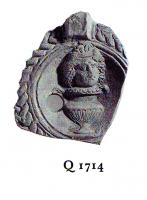 LMP-4810 - Lampe Loeschcke VIII Vase et masqueterre cuiteFragment de lampe ronde à bec rond . Médaillon décoré d'un vase sur lequel repose une tête couronnée, épaule ornée d'entrelacs en forme de corde.