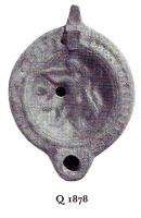 LMP-4849 - Lampe Loeschcke VIII Tritonterre cuiteTPQ : 100 - TAQ : 200Lampe ronde à bec rond. Médaillon décoré d'un triton à 2 queues, de face, jouant de la trombe et tenant le timon.