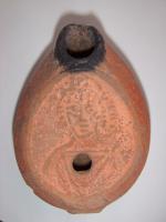 LMP-5119 - Lampe grenouille tardive Busteterre cuiteLampe ovoïdale. Disque décoré d'un buste de personnage de face féminin à longue coiffure soignée. Bec incorporé dans le réservoir. Argile noisette, engobe beige.