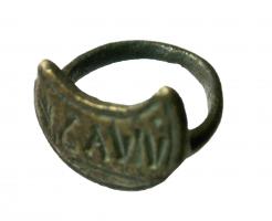 SIG-4028 - Signaculum en forme de lunulebronzeSignaculum coulé, en forme de lunule creusée pour dégager une inscription rétrograde, lettres en creux. Au revers, anneau gracile formant bague.