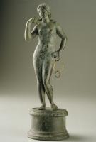 STE-4465 - Statuette : Aphrodite - Vénus à la toilettebronzeFigurine féminine nue, la déesse déhanchée (poids du corps sur la jambe droite) tient une mèche de cheveux dans la main droite relevée; la main gauche est posée sur la hanche.